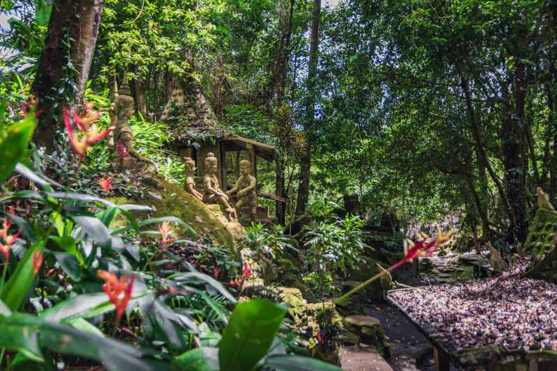 Tarnim and Magic Garden mit vielen Buddha-Statuen im Regenwald